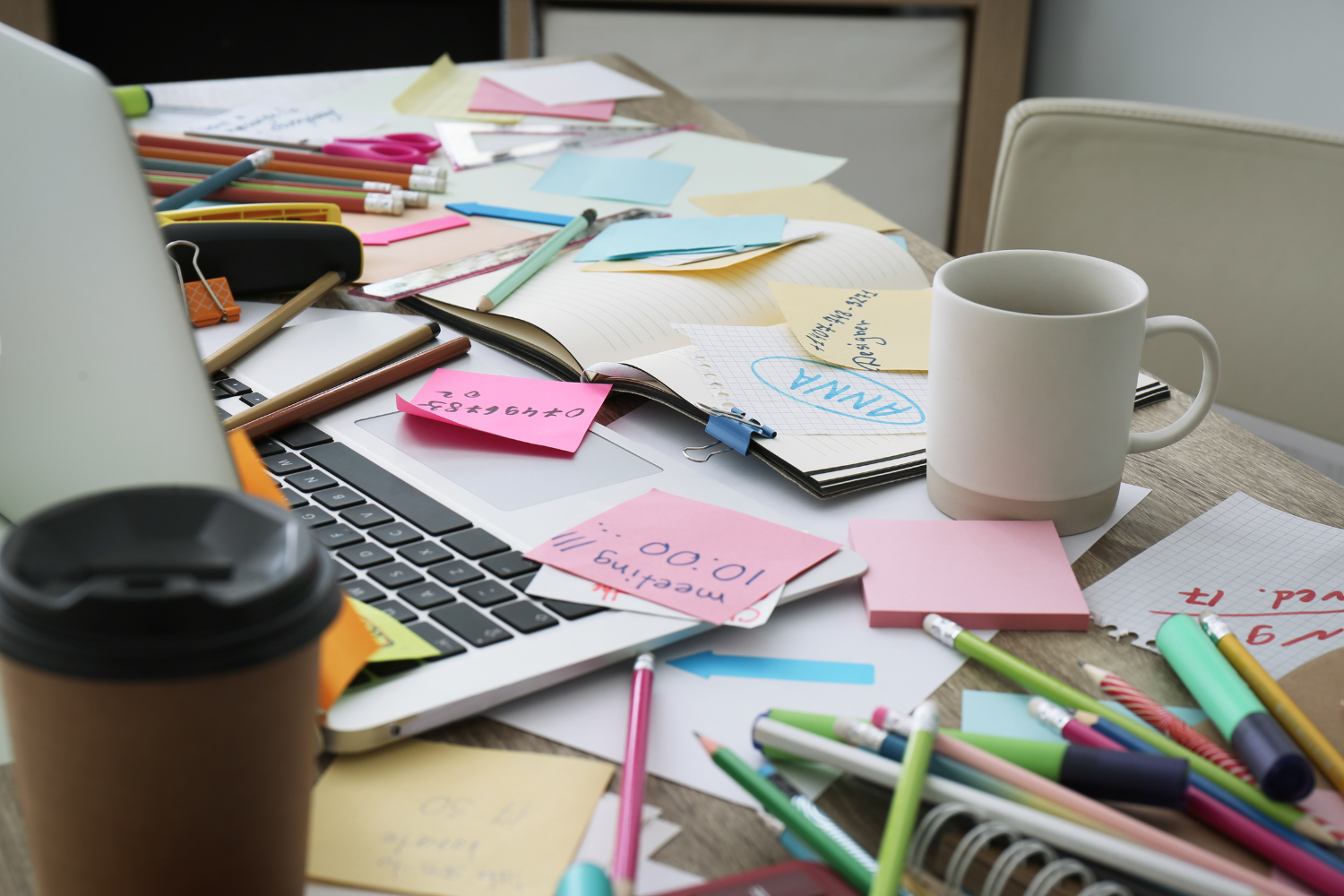 5 Signs It's Time to Automate Your Client Management | Virtually Done Systems | A cluttered, messy desk top with post-it notes all over.